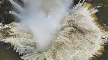 Raging Iguazu Falls water rushing into depths surrounded by mist, rocky cliffs video