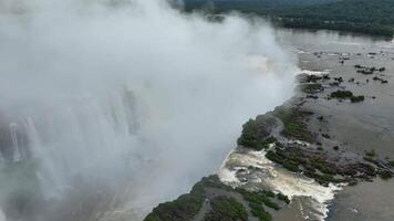 Aerial view of Iguazu Falls with rising mist over jungle and vast river video