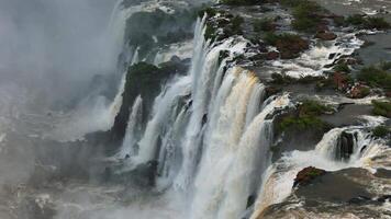 Aerial. Iguazu Falls with waterfalls pouring from cliffs into roaring canyon video
