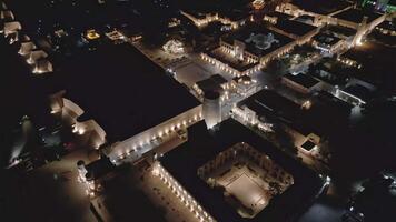 Lit-up Khiva shines beneath the stars in detailed aerial view video