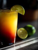 Tequila Sunrise Cocktail in a Glass with Lime Garnish. photo