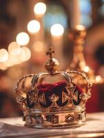 Close up of a Golden Crown with Red Velvet and Gems, Resting on a White Surface. photo