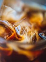 Close Up of Iced Coffee with Cream Swirls and Melting Ice Cubes. photo