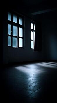 Sunlight Streaming Through Windows in a Dark Room. A moody image of an empty room illuminated by light from two windows. photo