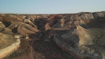 Aerial view of striped Aktumsuk buttes and Martian valleys at golden sunset video