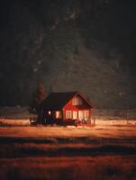 Illuminated Cabin in a Serene Sunset Meadow. A picturesque scene of a cozy red cabin glowing warmly against a dramatic sunset backdrop. photo