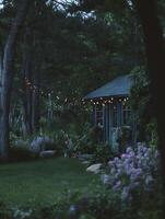 Enchanting Evening at a Rustic Cabin in the Woods. String lights illuminate the cozy scene. photo