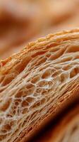Extreme close up of the flaky layers in a delicious pastry, showcasing its golden brown crust and airy texture. photo