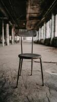 A Rusty Metal Chair in an Abandoned Factory Building. photo