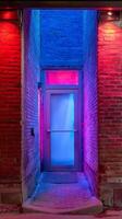 Illuminated Brick Alleyway with Door at Night. A vibrant image showcasing a doorway bathed in contrasting red and blue light. photo