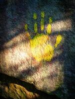 Ancient Handprint on Rock Surface, Illuminated by Sunlight. photo