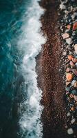 Ocean Wave Meeting Colorful Pebbles on a Shore. A close up view of the meeting point of sea water and a beach. photo