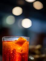 Close up of an Aperol Spritz cocktail in a rocks glass with an orange slice garnish, illuminated by warm lighting. photo