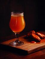 Amber Ale and Spicy Chicken Wings on Rustic Wooden Board. photo