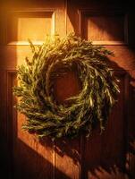 Rosemary Wreath Hanging on a Wooden Door in Warm Sunlight. A rustic image perfect for seasonal or home decor projects. photo