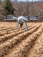 Aerial Photography Drone Flying Over Farmland. A close up image of a drone in flight above freshly plowed fields. photo