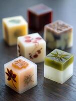 Close up of Decorative Cubes with Embedded Botanical Elements on a Dark Wood Surface. photo