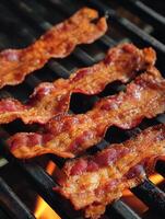 Close up of Crispy Bacon Strips Grilling on a Barbecue Grill. photo