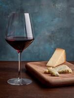 Red Wine and Cheese Tasting A Delicious Pairing on Wooden Board. photo