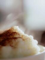 Close Up of Steaming Rice Pudding with Cinnamon. A delicious and comforting food image perfect for culinary blogs and recipe websites. photo