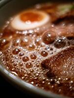 Close up of Ramen Broth with Bubbles and Soft Boiled Egg. photo
