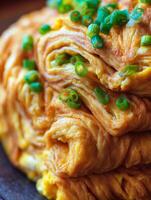 Close up of Delicious Rolled Omelet Garnished with Green Onions. photo