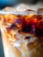 Close Up of Iced Coffee with Cream Swirls and Ice Cubes. A Detailed Macro Photograph of a Refreshing Beverage. photo