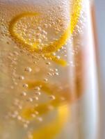Close Up of Sparkling Water with Lemon Zest. A detailed macro photograph of bubbles and citrus in a refreshing drink. photo