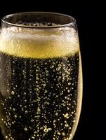 Close up of Sparkling Wine in a Glass, Bubbles and Foam Detail. photo