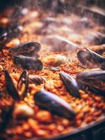 Steaming Hot Seafood Paella with Mussels and Clams. A close up image of a delicious paella dish. photo