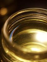 Close up of Golden Liquid in Glass Jar, Abstract Texture Background. photo