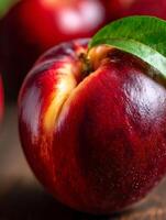 Close Up of a Ripe Nectarine with a Green Leaf. A vibrant image showcasing the texture and color of a single nectarine. photo
