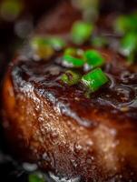 Close Up of a Delicious, Glazed Steak Topped with Green Onions. photo
