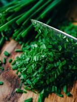 Close Up of Freshly Chopped Chives on a Wooden Cutting Board. photo