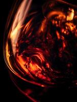 Abstract Close Up of Amber Liquid Swirling in a Glass. A fiery, dynamic image perfect for backgrounds or design projects. photo