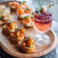 Gourmet Appetizers and Sparkling Pomegranate Cocktail on Wooden Tray. photo