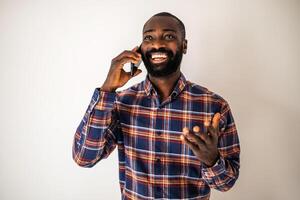 African American man in his 30s talking on a mobile phone, smiling and relaxed, wearing casual clothes, with copy space in the background. photo