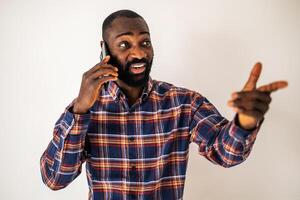 Handsome African American male in his 30s looking away with a satisfied smile as he communicates on his mobile phone. photo