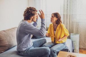 A couple indoors showing anger and disappointment while trying to communicate their issues. photo