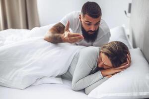 A man and woman express anger and disappointment while discussing problems at home, showing the emotional toll of misunderstandings. photo