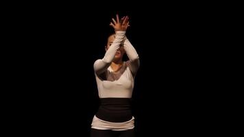 A dancer performing expressive hand movements against a black background, showcasing grace and emotion in a minimalist setting. video