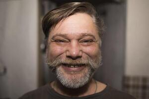 A man with facial hair is happily smiling for a portrait photograph photo