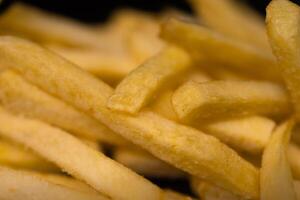 Close-up of golden crispy french fries, showcasing their delicious texture and appeal as a popular fast food snack or indulgent side dish photo
