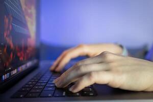 Human hands actively typing on a laptop keyboard with a glowing screen, representing remote work, digital communication, and focused productivity in a modern tech setting photo