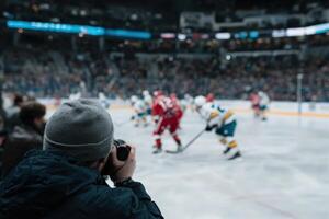 Fan takes picture of Hockey Game at arena photo