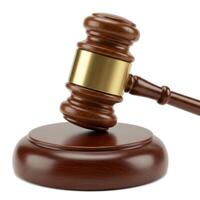 A polished wooden gavel with a brass band rests on its sounding block symbolizing justice and authority photo