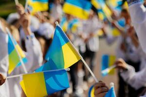 The concept of the young generation of Ukraine. Many Ukrainian children hold the yellow and blue flag in their hands. photo