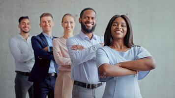 A diverse group of professionals stands in a line within a modern office. They are dressed in business attire, exuding confidence and readiness for challenges. video