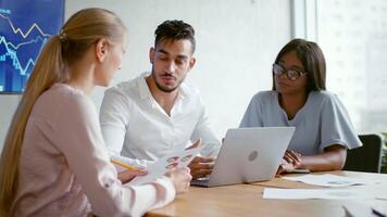 Three professionals engaged in a discussion at an office table, analyzing charts and strategy documents. The atmosphere conveys teamwork and collaboration during a successful planning session. video