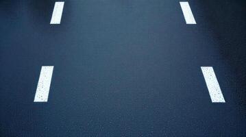 An empty road with white lines painted on it photo